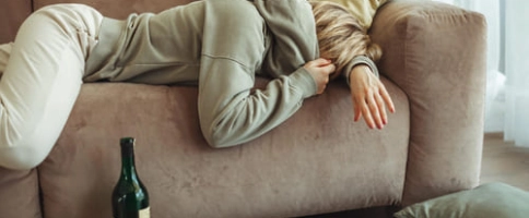 женщина с похмельем лежит на диване